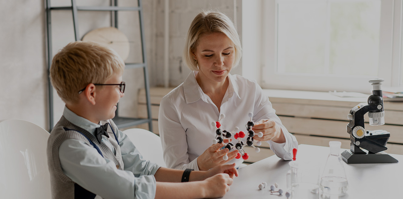 Female science tutor in Greensboro studying chemistry with student